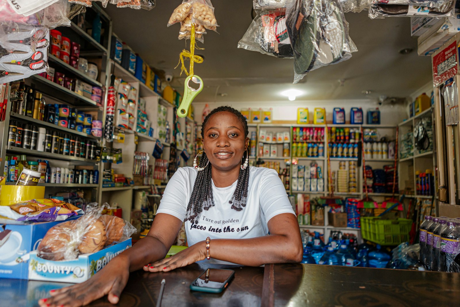 A shopkeeper leans on the counter of her general store in Tanzania